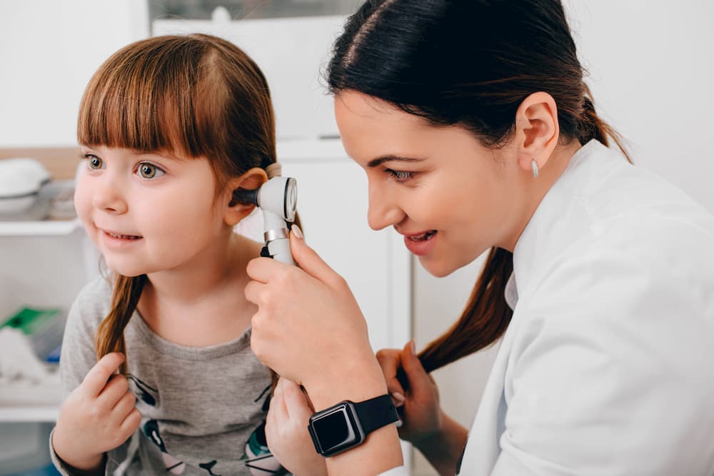 doctor checking ears of a young little girl 